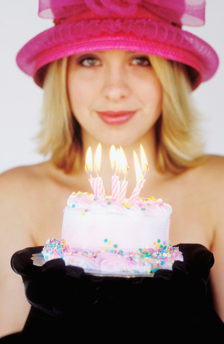 Junge Frau mit einem kleinen Geburtstagskuchen