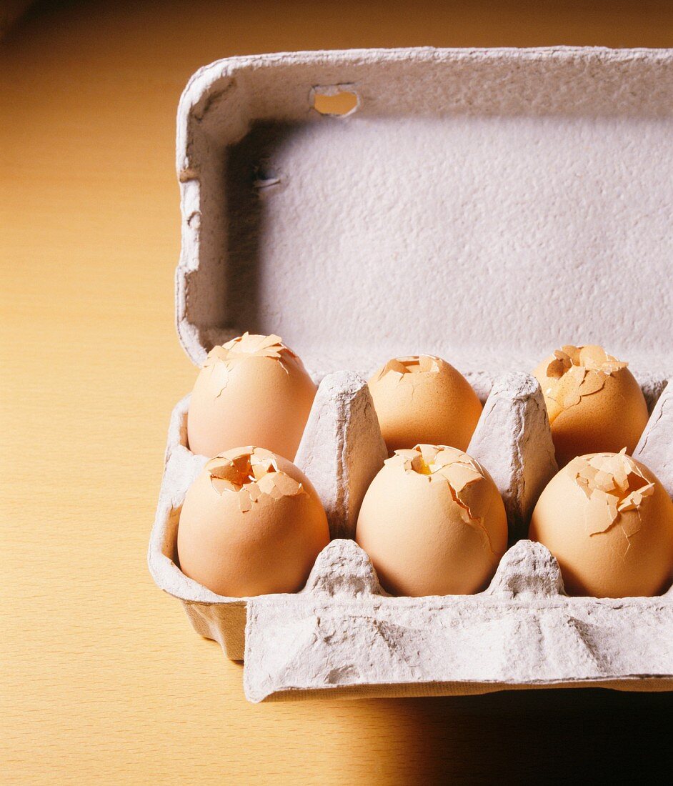 Cardboard egg carton with shattered eggs