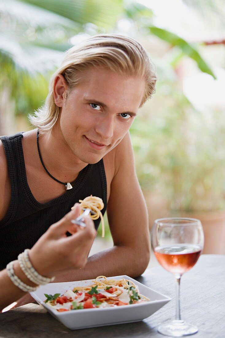 Young man eating spaghetti