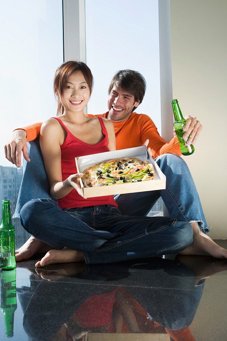 Young couple with beer and pizza