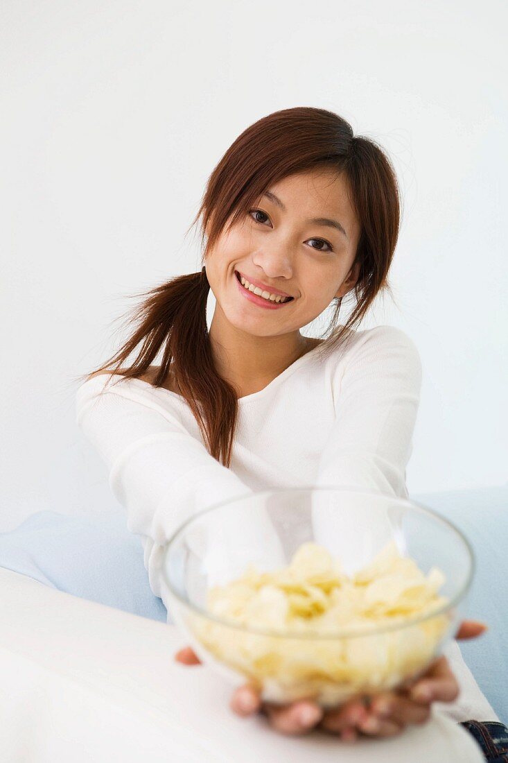 Young woman eating crisps