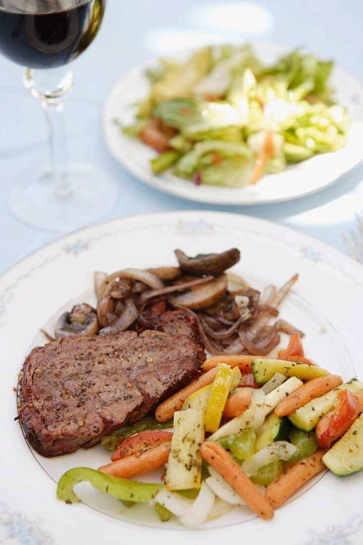 New York steak with vegetables and salad