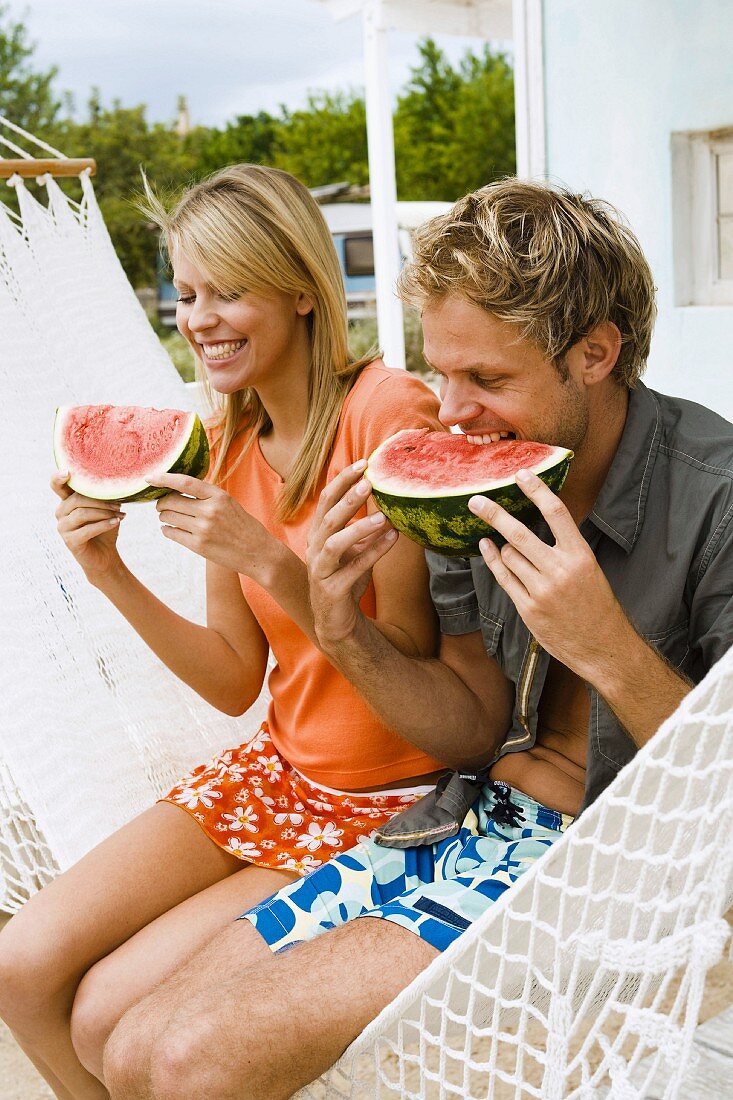 Young couple eating watermelon