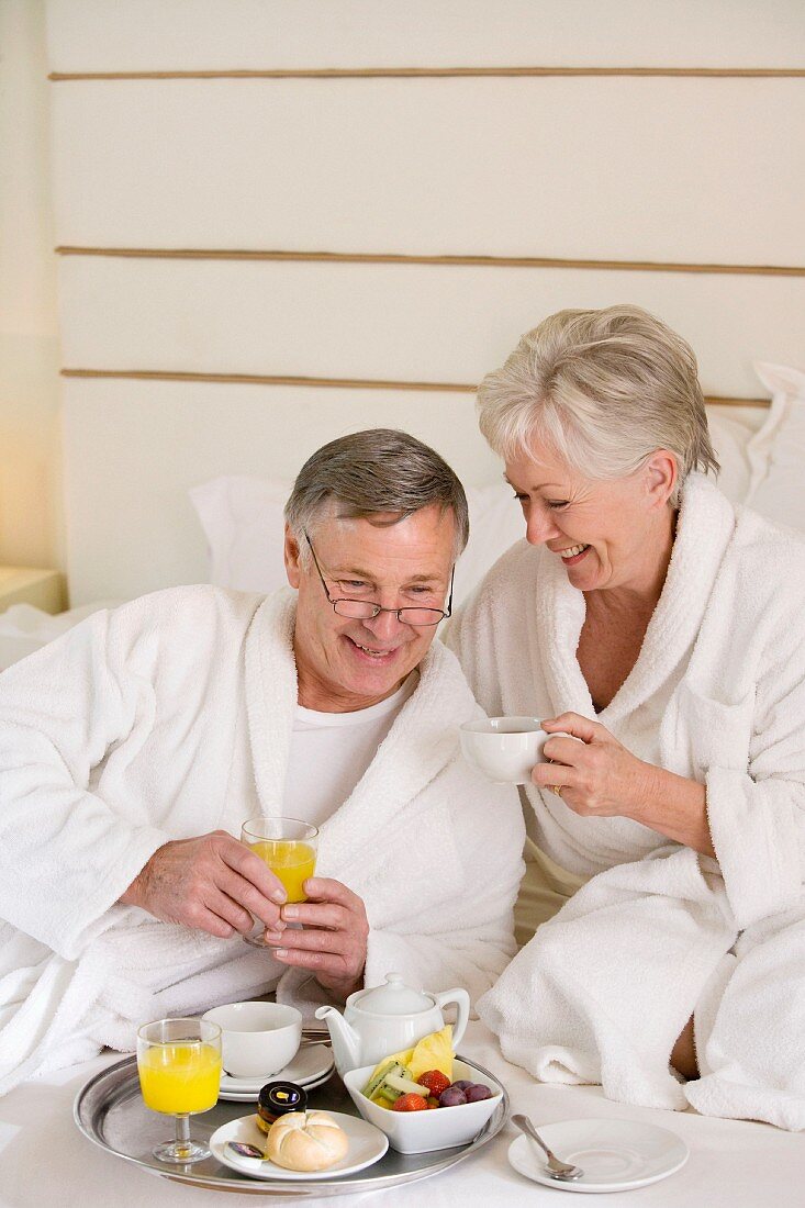 Älteres Ehepaar beim Frühstücken im Bett