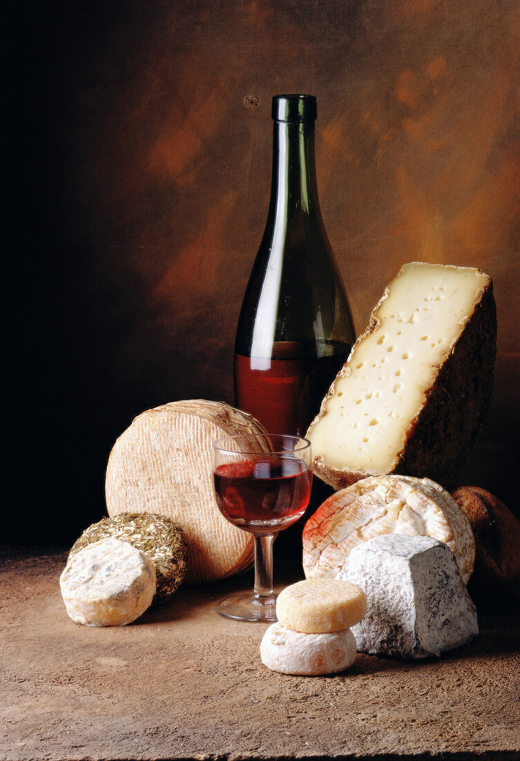 Selection of cheeses with bottle and glass of red wine