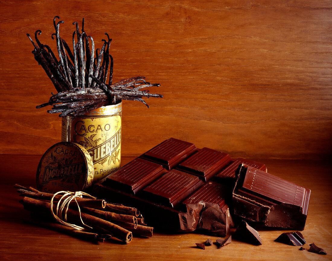 Angebrochene Tafel Zartbitterschokolade mit Zimtstangen und Vanilleschoten