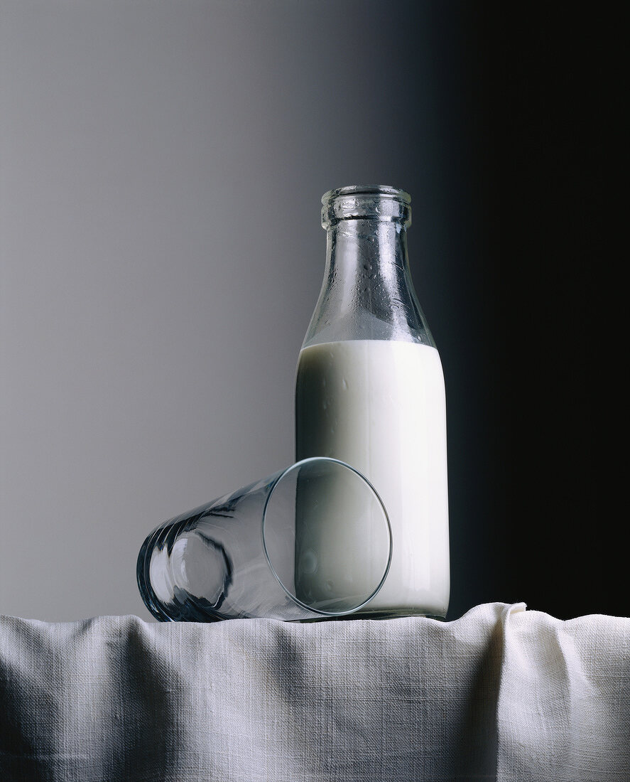 Eine Milchflasche mit einem leeren Glas