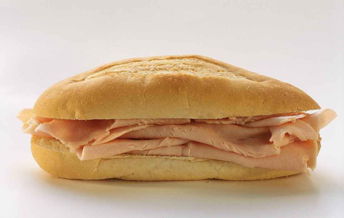 Baguette-Sandwich mit Putenschinken auf hellem Untergrund