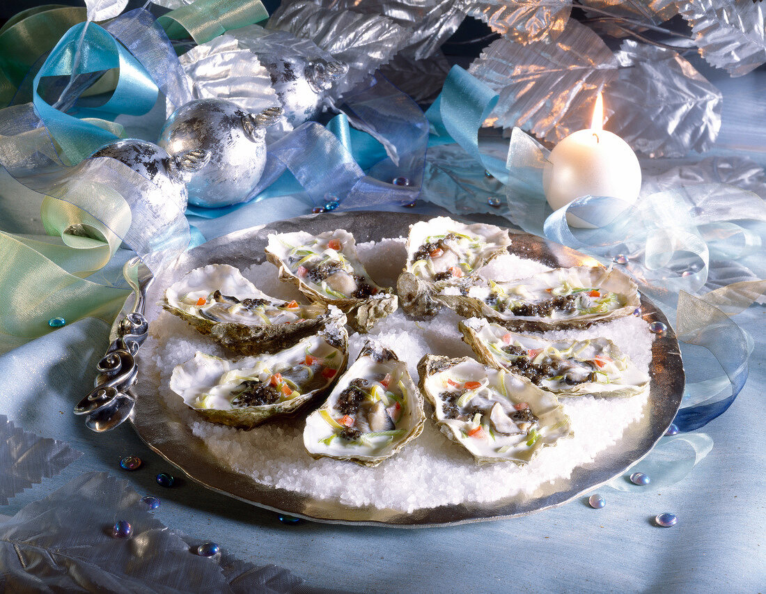 Platte mit pochierten Austern und Kaviar auf Salzbett