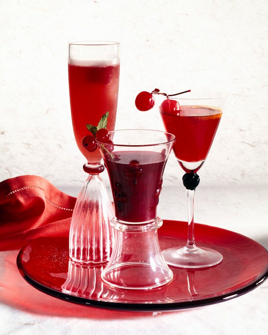 Dreierlei rote Cocktails (Campari, Kirsche und Johannisbeere)