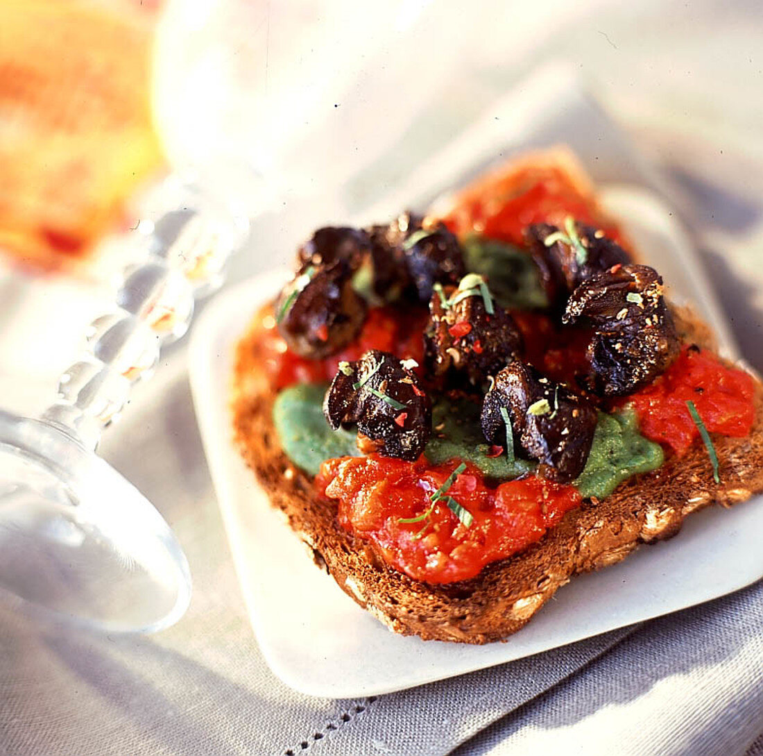 Weinbergschnecken mit Petersilienbutter und Tomaten auf Kornbrot