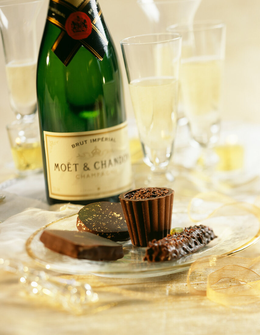 Schokoladenkonfekt auf einem Glasteller mit Champagner