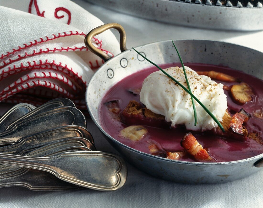 Poached egg with country bread, fried bacon and red wine sauce