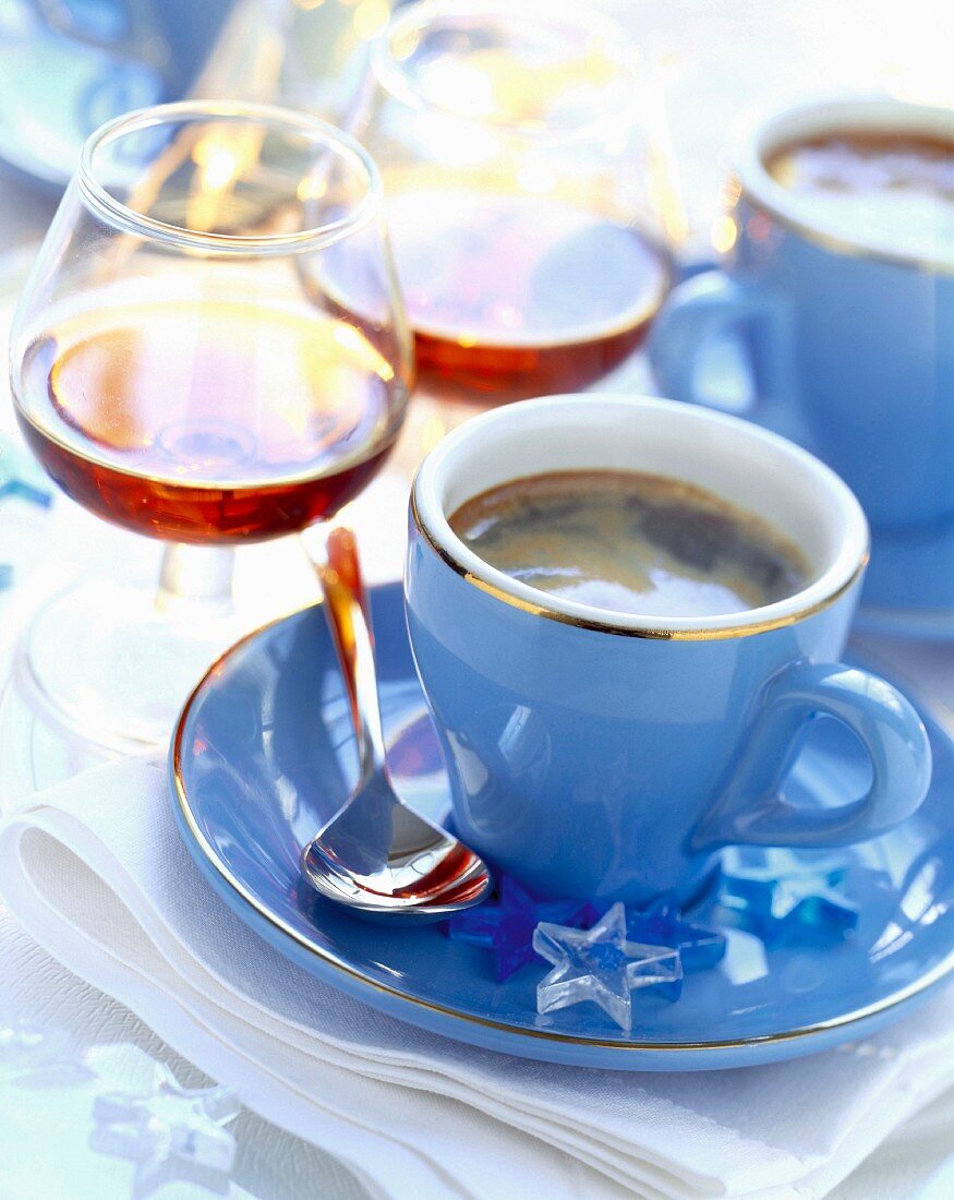 Kaffee in blauer Tasse und Cognac in Gläsern