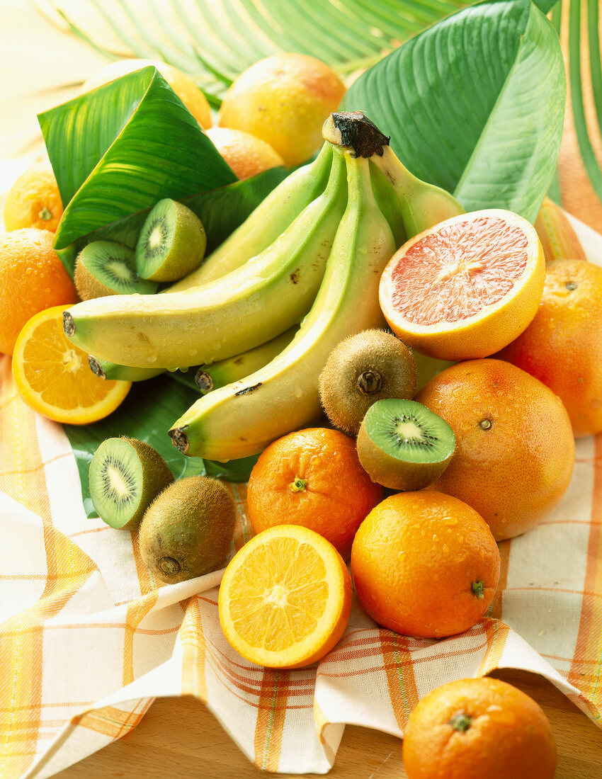 Bananen, Orangen und Kiwis auf Geschirrtuch