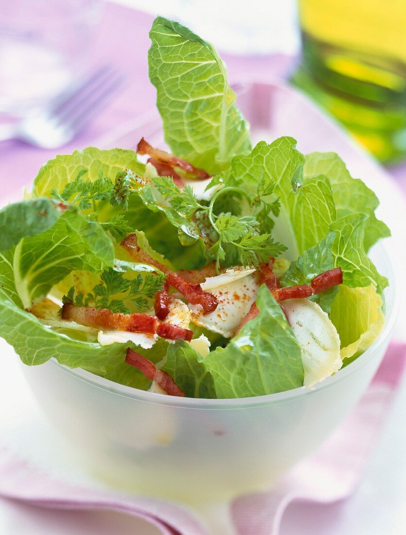 Salad with flakes of goat cheese and diced bacon