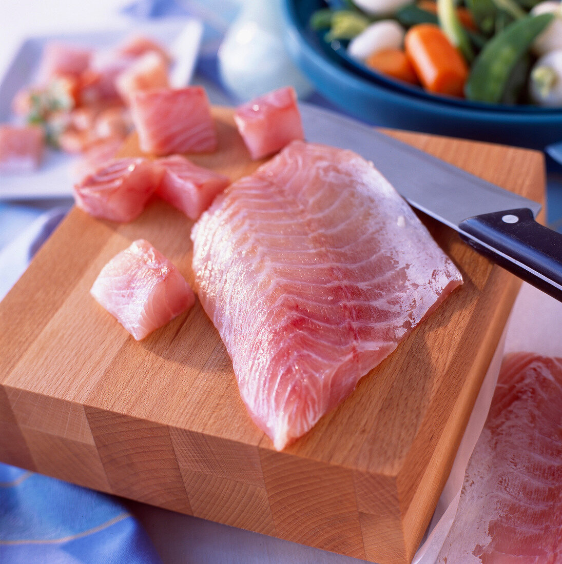 Raw fillet of perch on chopping board with knife