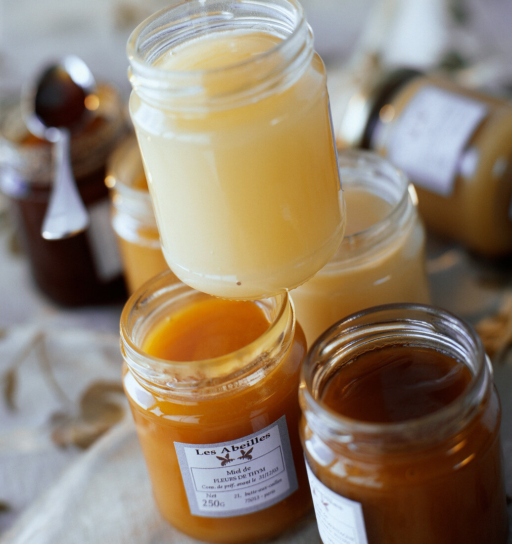 Geöffnete Schraubgläser mit verschiedenen Honigsorten