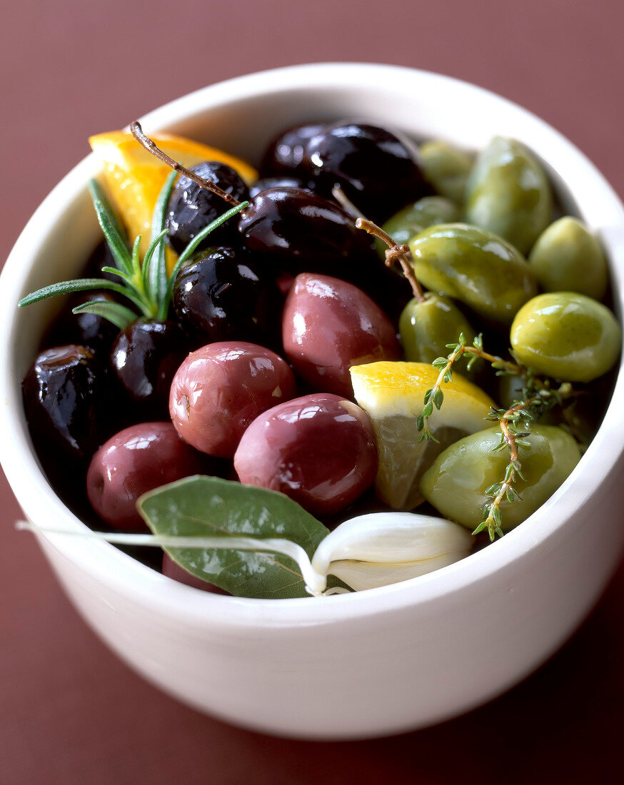 Schale mit verschiedenen Oliven, Kräutern und Gewürzen
