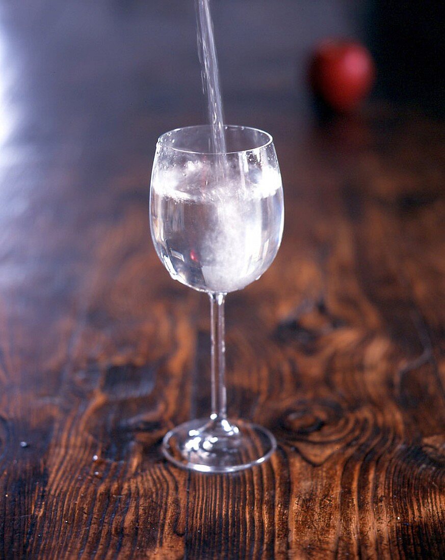 Wasser läuft in Weinglas