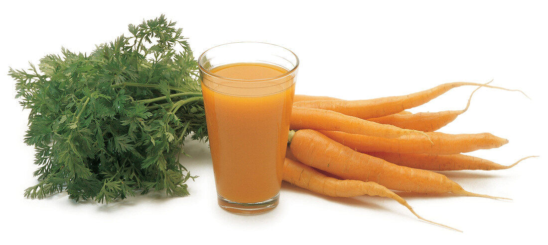 Bunch of carrots with glass of carrot juice