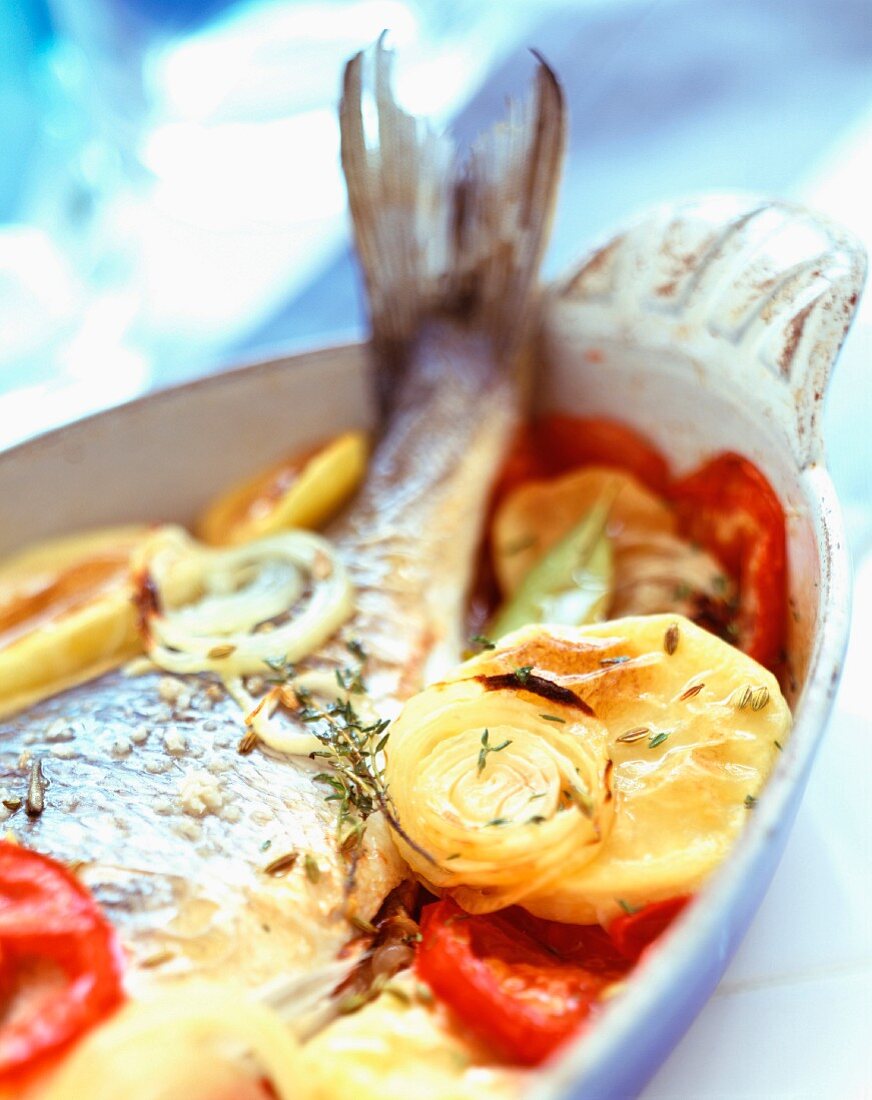 Gebackener Fisch mit Gemüse und Thymian in einer Ofenform