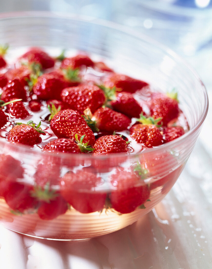 Fresh strawberries in bowl of water