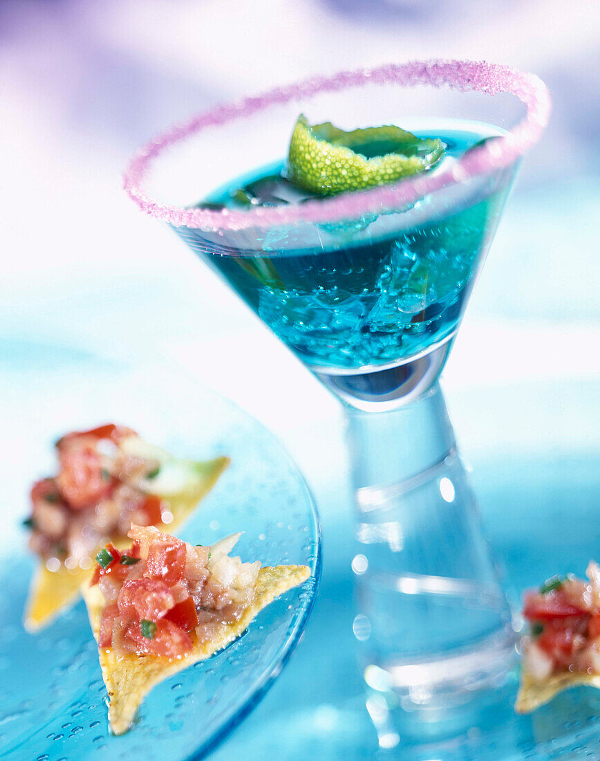 Blauer Curacao-Cocktail mit Tortillachips-Häppchen