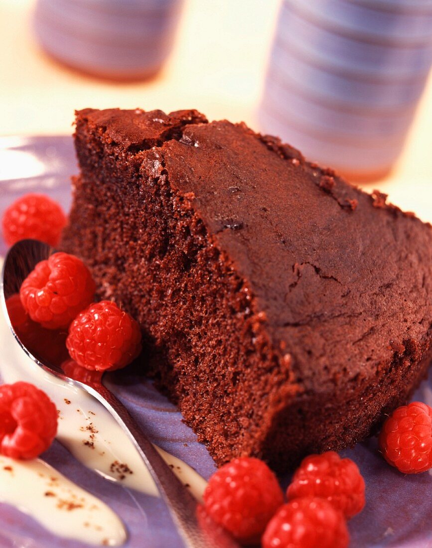 Slice of moist chocolate cake with raspberries