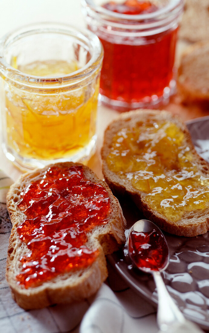 Slices of bread and jam with jars of jam
