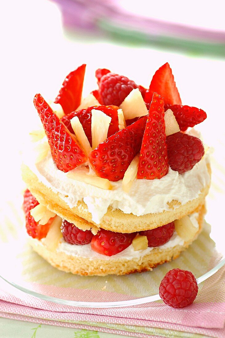 Strawberry cream sponge dessert with raspberries and pineapple