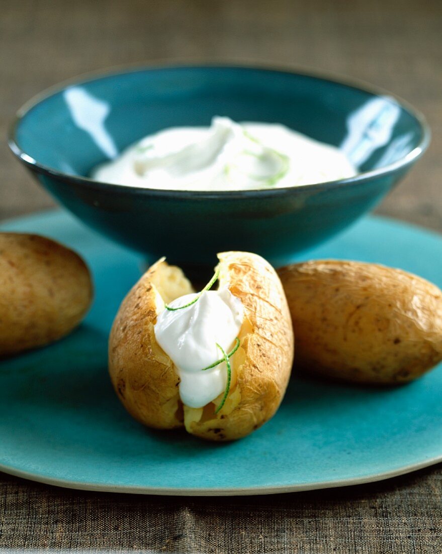 Baked potatoes with whipped cream and lime zests