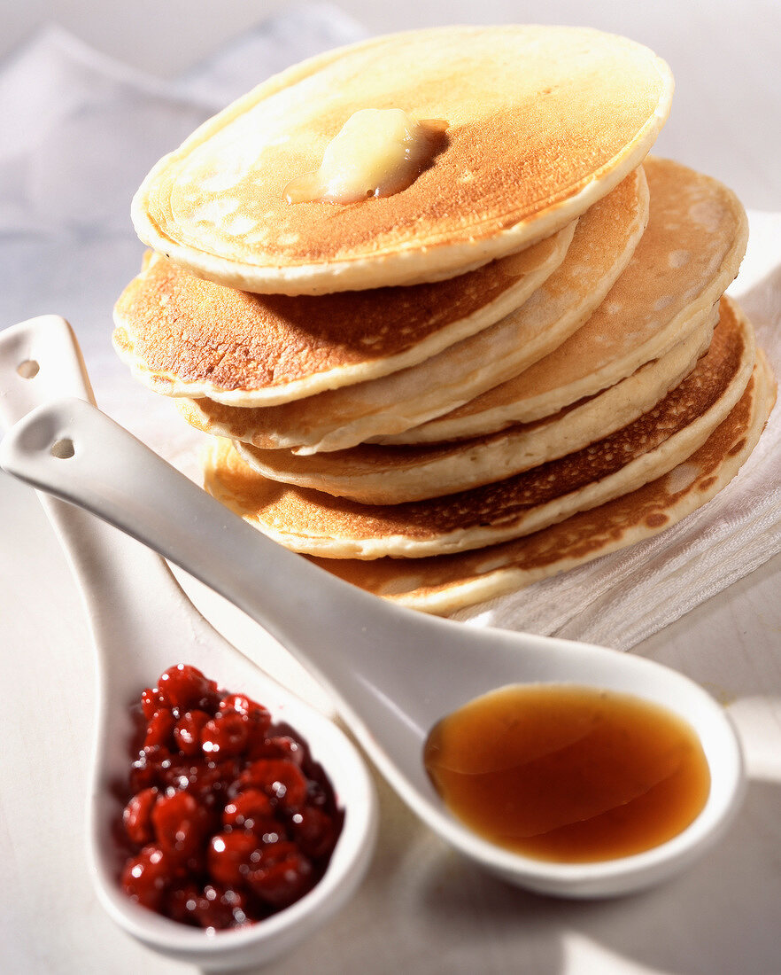 Ein Stapel Pancakes mit Cranberries und Ahornsirup