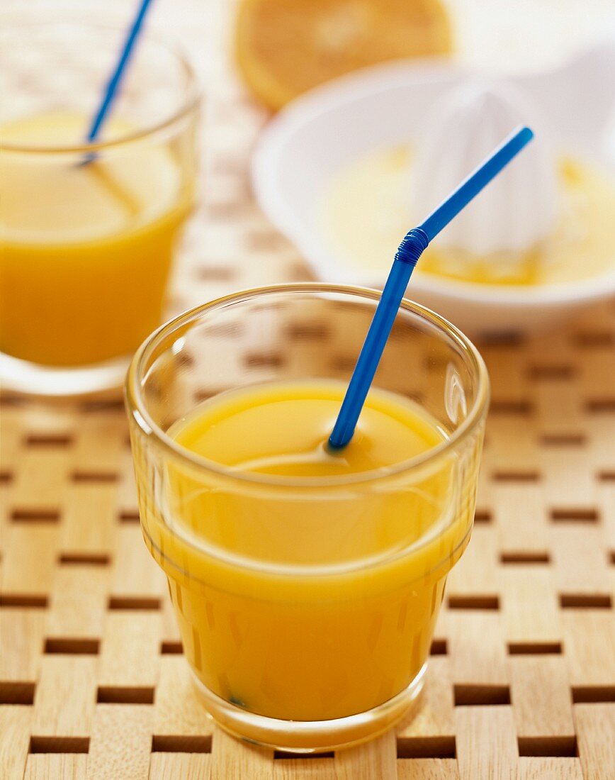 Orangensaft im Glas mit Strohhalm