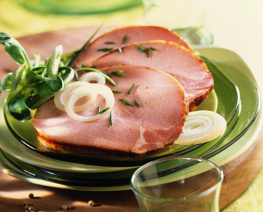 Kasslerbraten in Scheiben mit Kräutern und Zwiebelringen