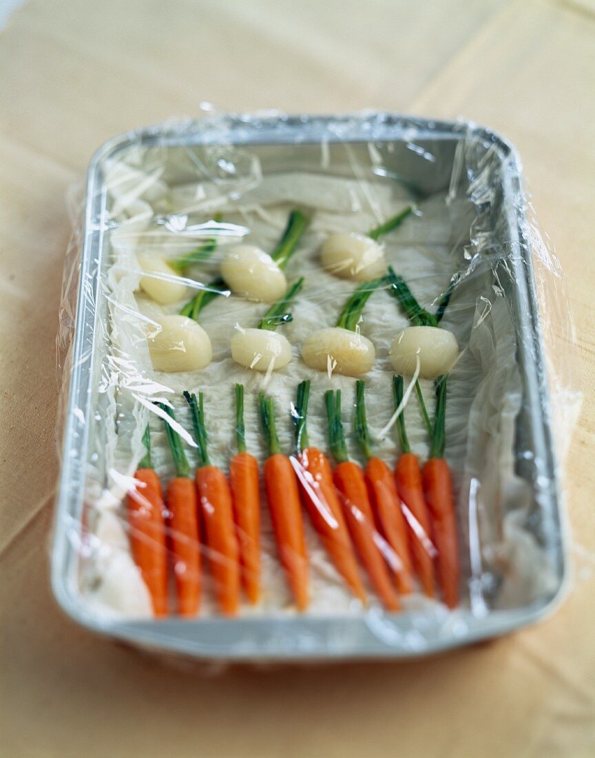 Baby vegetables covered in cling film