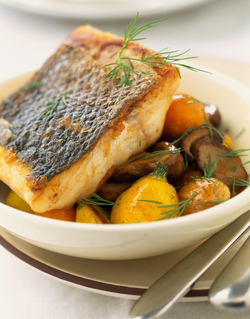 Piece of roast bass with ceps, chestnuts and kumquats