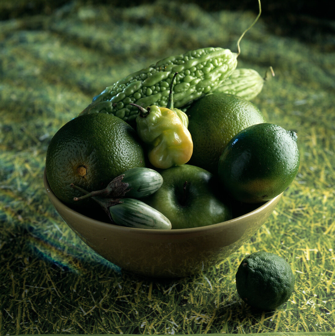 Grünes Obst und Gemüse in Schale auf grünem Untergrund