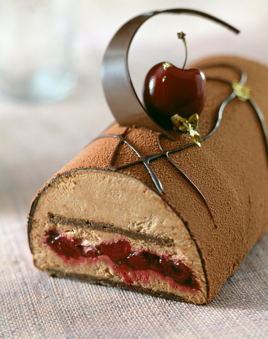 Französischer Baumstammkuchen mit Schokolade und Kirschen