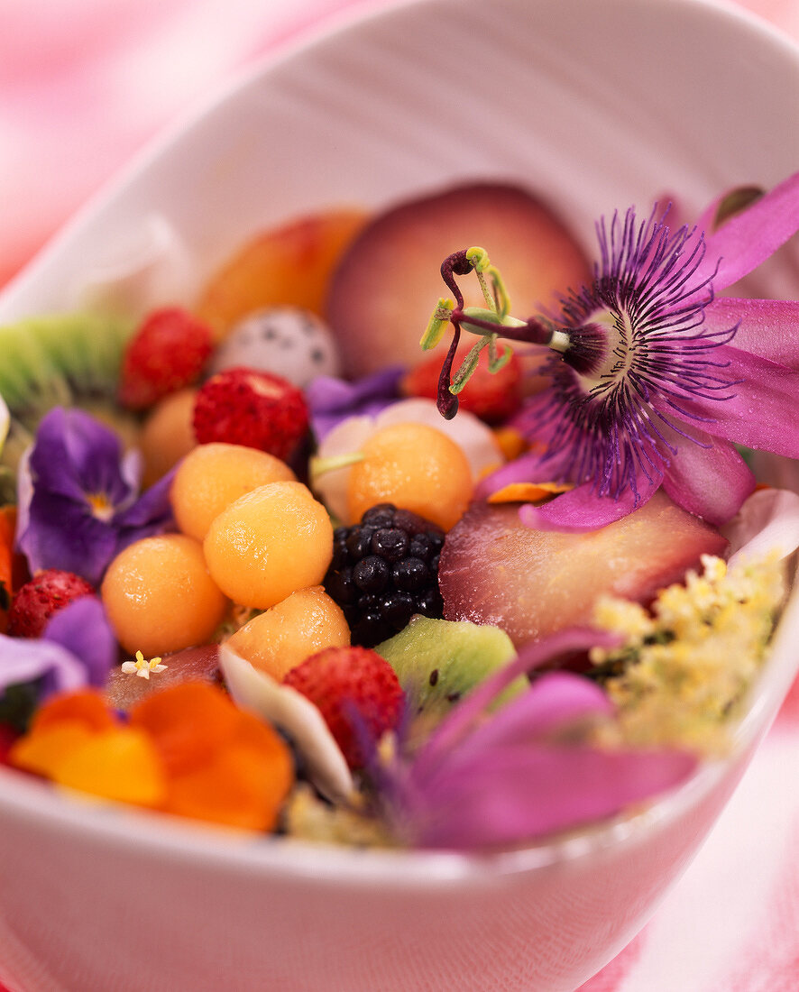 Mixed summer fruit salad with passionfruit flowers