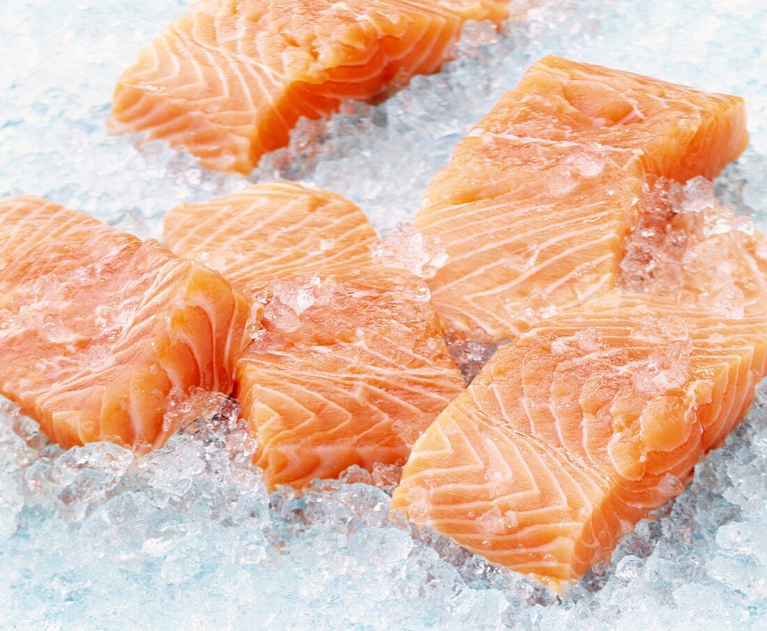 Raw pieces of salmon on ice
