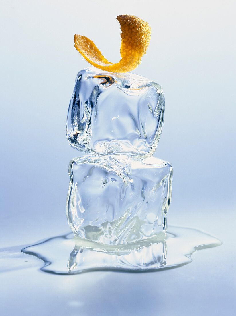 Ein Stück Orangenschale auf zwei Eiswürfeln