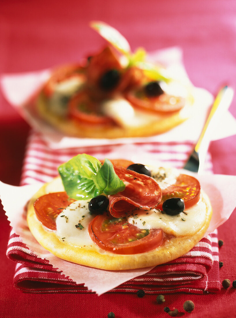 Minipizzas mit Mozzarella, Tomate und Salami