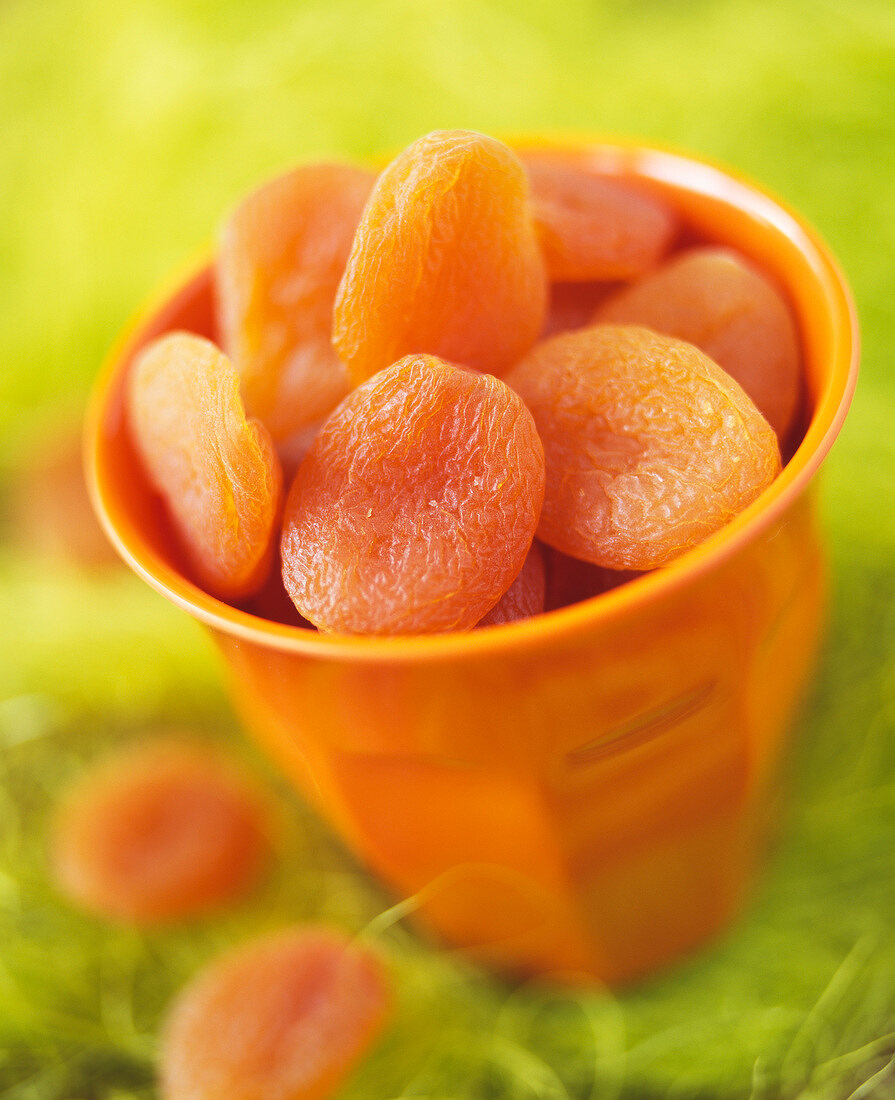 Getrocknete Aprikosen in orangefarbener Tasse