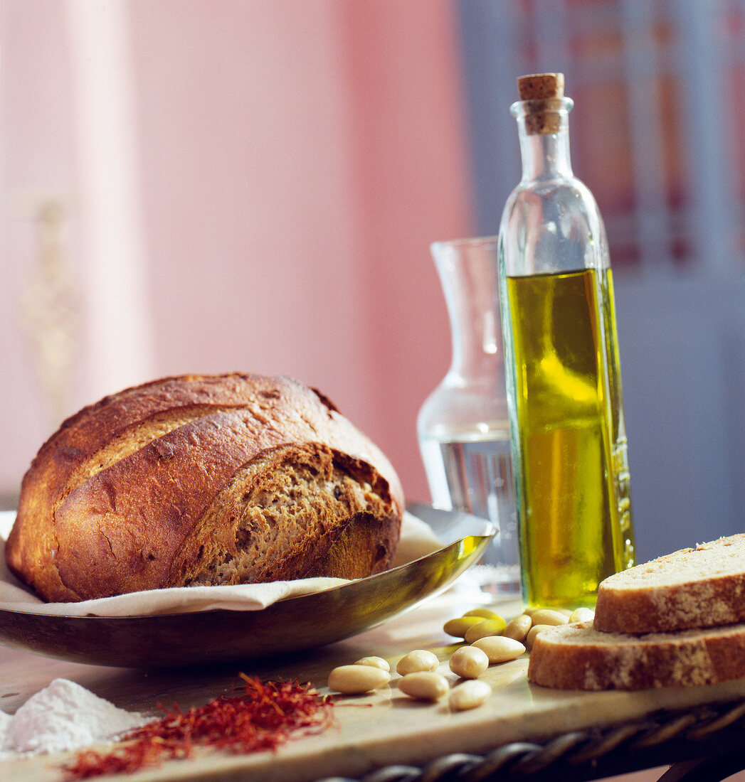 Stillleben mit Landbrot, Safran, Mandeln und Olivenöl