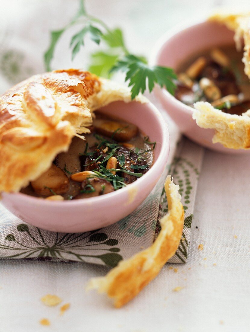 Cream of mushrooms with pinenuts and covered with pastry crust