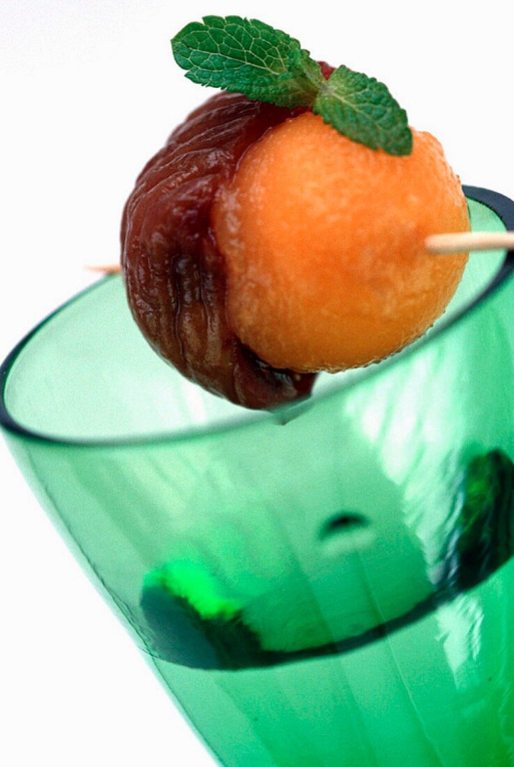 A drink with a fruit skewer