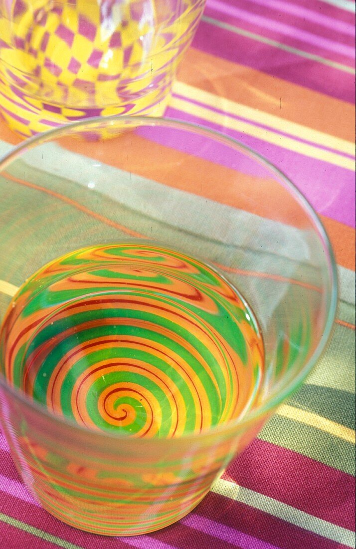 A glass with a colourful spiral pattern