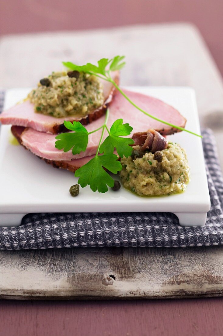 Slices of roast pork with green sauce