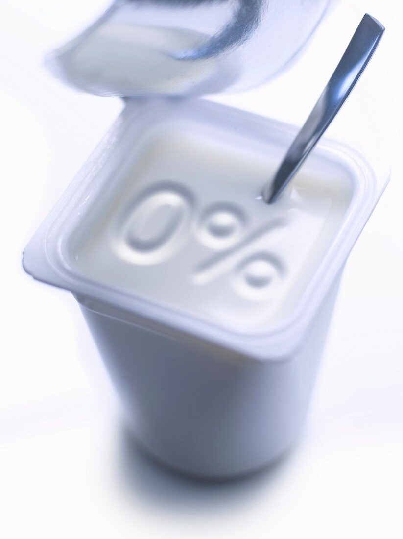 Geöffneter Becher Naturjoghurt 0% Fett mit Löffel